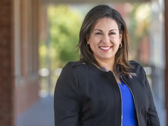 A photo of Renee Marquez in front of the Old Main Building 