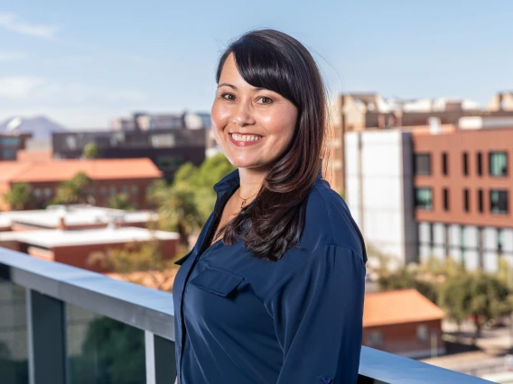 Candace Geary, co-chair of the Parent & Family Association is standing on the balcony at the University of Arizona campus overlooking the western skyline