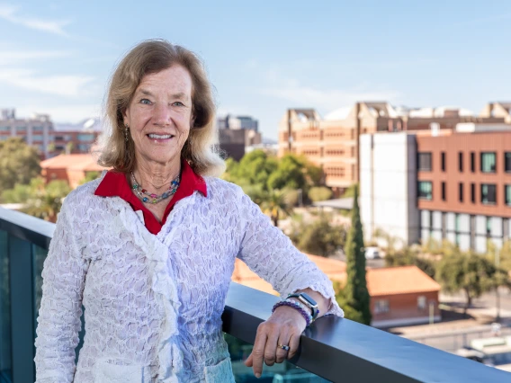 Photo of Jennifer Finger from the Parent & Family Association Board standing on balcony with the western skyline behind her