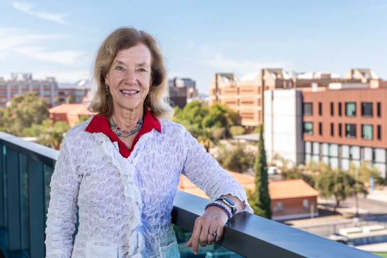 Photo of Jennifer Finger from the Parent & Family Association Board standing on balcony with the western skyline behind her